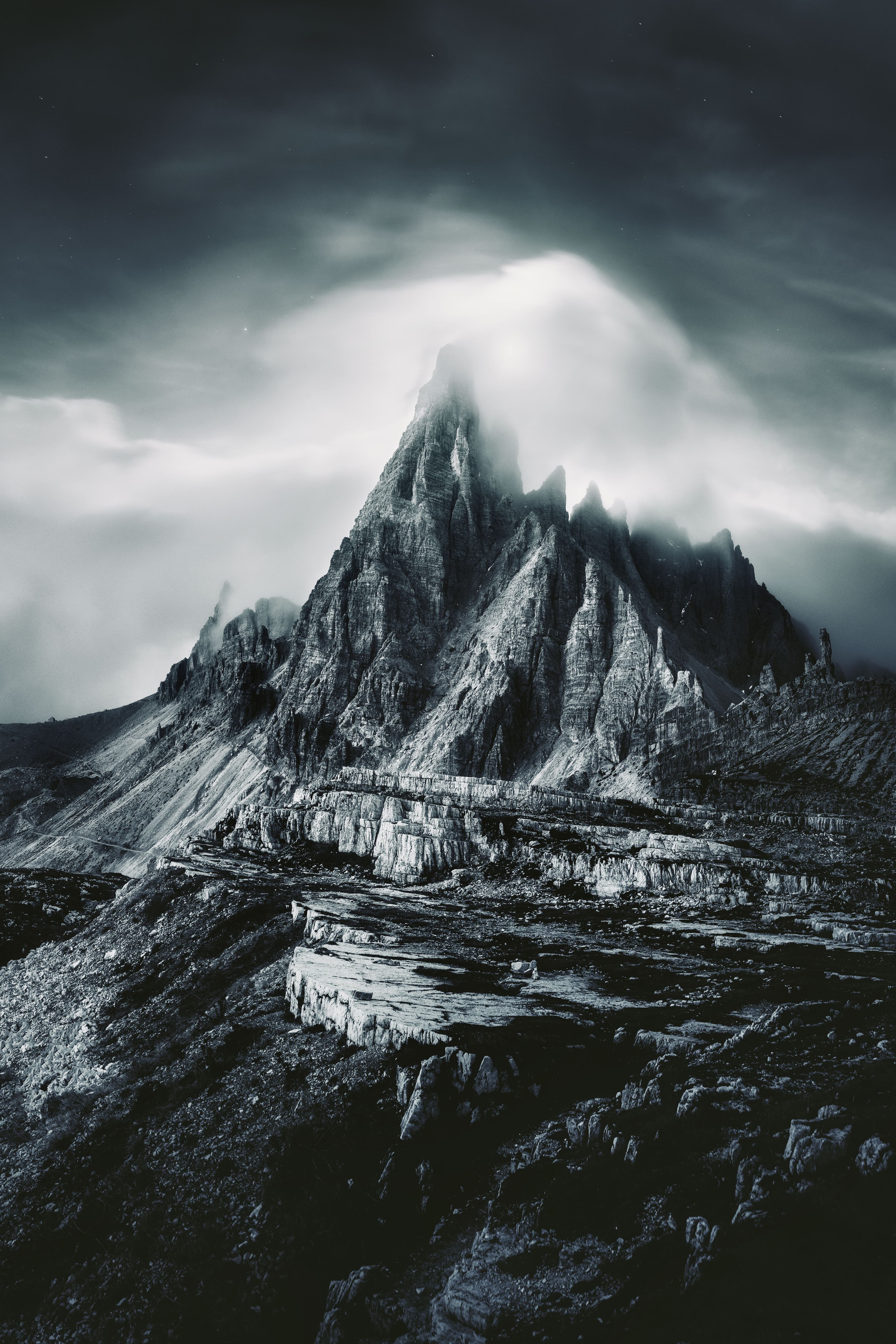 A monumental mountain summit beneath moving clouds